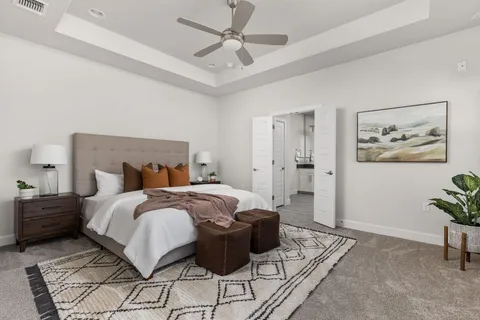 a spacious bedroom with a bed a couch and a chandelier