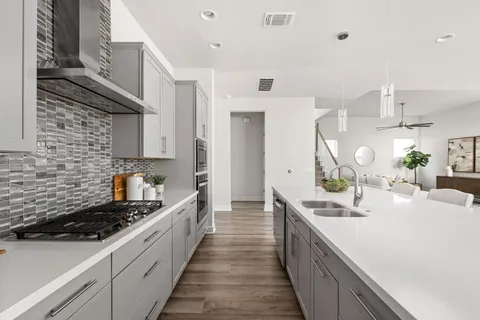 a large kitchen with kitchen island a sink a counter space and stainless steel appliances