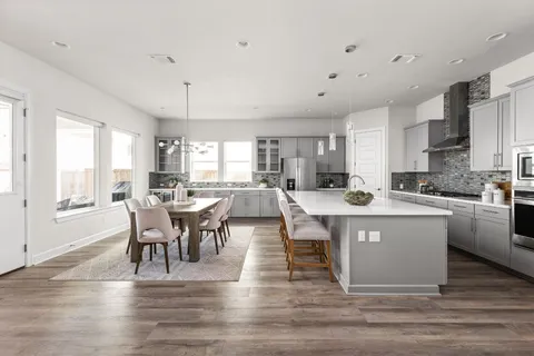 a large kitchen with a table and chairs