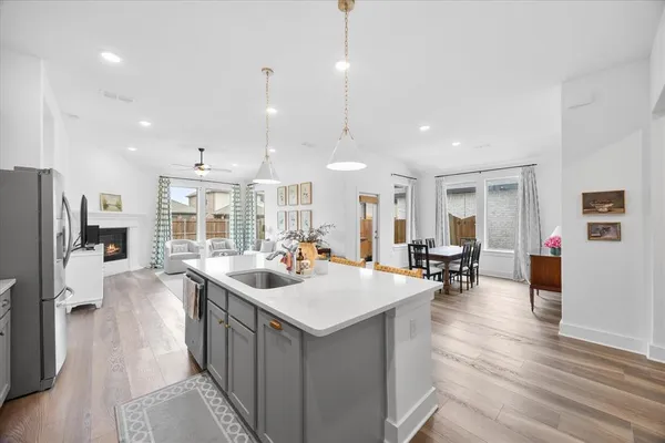 a kitchen with kitchen island a white stove top oven a chimney wooden floor and cabinets