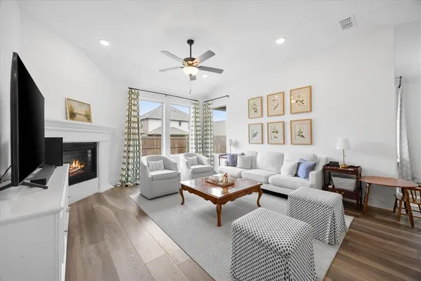 a living room with furniture a flat screen tv and a large window