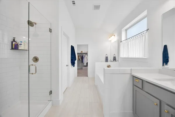 a en suite bathroom with a double vanity sink a mirror and a bathtub