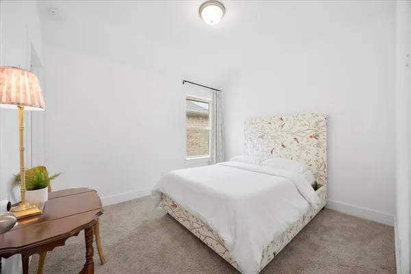 a bedroom with a bed a table and painting