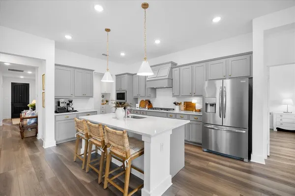 a kitchen with a sink a stove and chairs