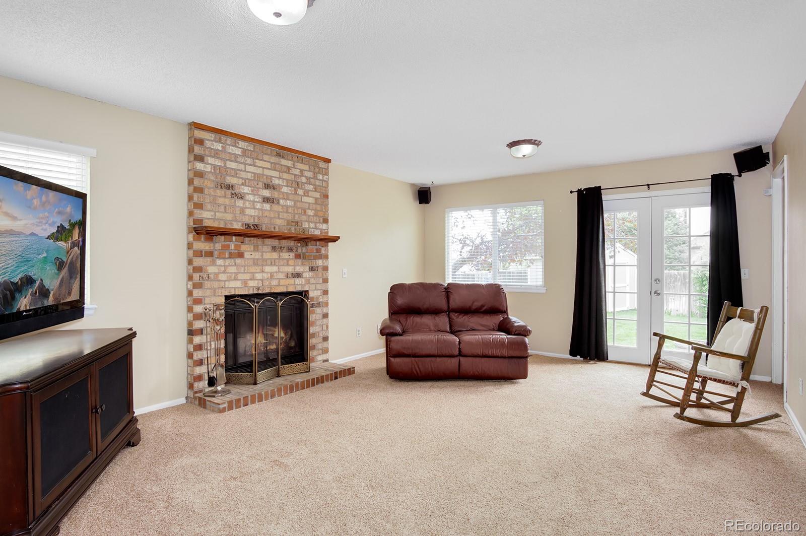 417 Ridgeglen Way Highlands Ranch, CO 80126 - Photo 11 of 33 a living room with furniture a flat screen tv and a fireplace