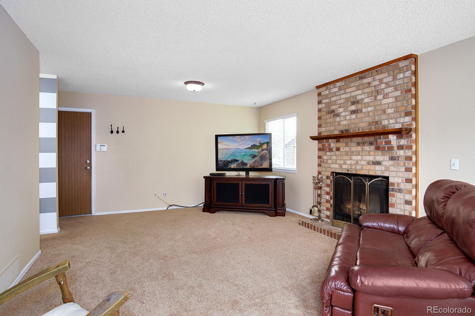 417 Ridgeglen Way Highlands Ranch, CO 80126 - Photo 12 of 33 a living room with furniture a flat screen tv and a fireplace