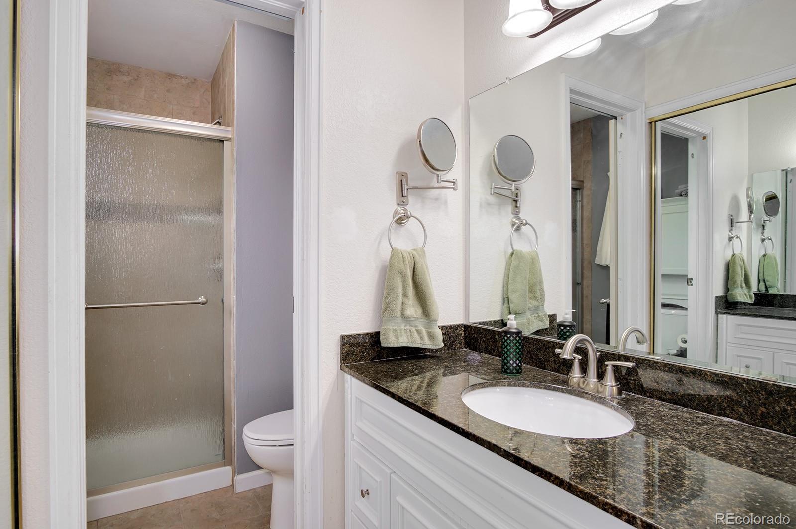 417 Ridgeglen Way Highlands Ranch, CO 80126 - Photo 17 of 33 a bathroom with a granite countertop sink and a mirror