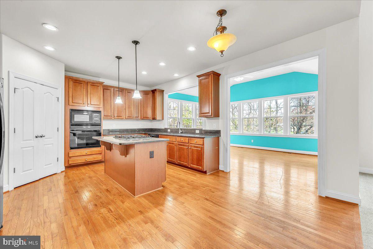 9588 Clover Hill Road Manassas, VA 20110 - Photo 12 of 32 a kitchen with stainless steel appliances granite countertop a stove a sink and a wooden floors