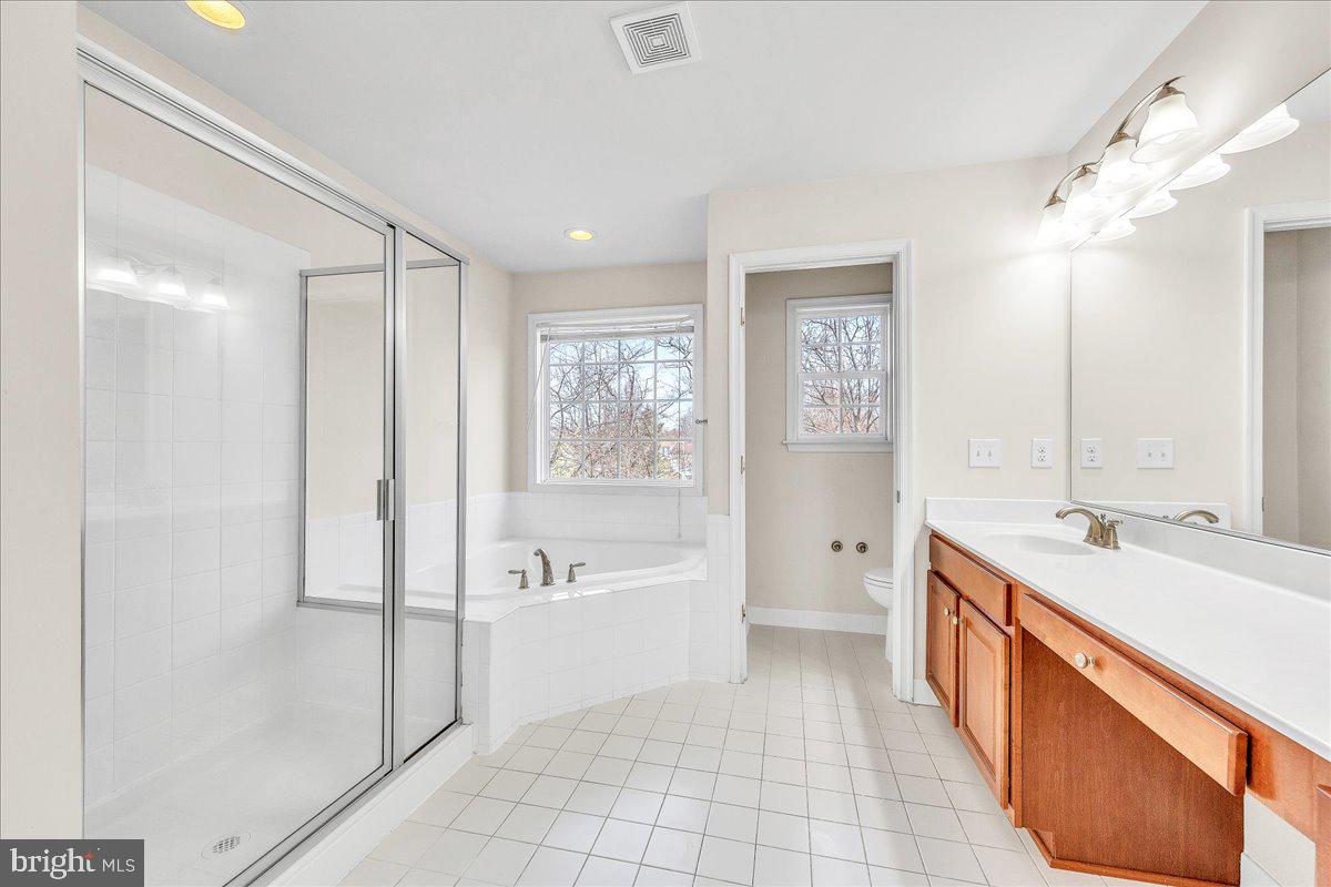 9588 Clover Hill Road Manassas, VA 20110 - Photo 20 of 32 a spacious bathroom with a tub sink and mirror