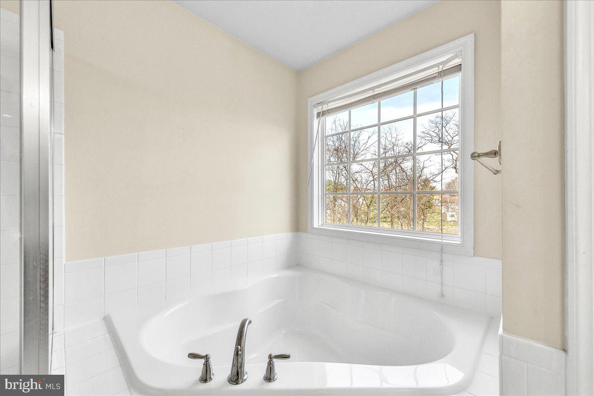 9588 Clover Hill Road Manassas, VA 20110 - Photo 21 of 32 a white bath tub sitting in a bathroom next to a window