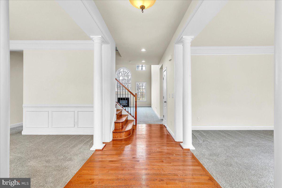 9588 Clover Hill Road Manassas, VA 20110 - Photo 3 of 32 a view of a hallway with wooden floor and staircase