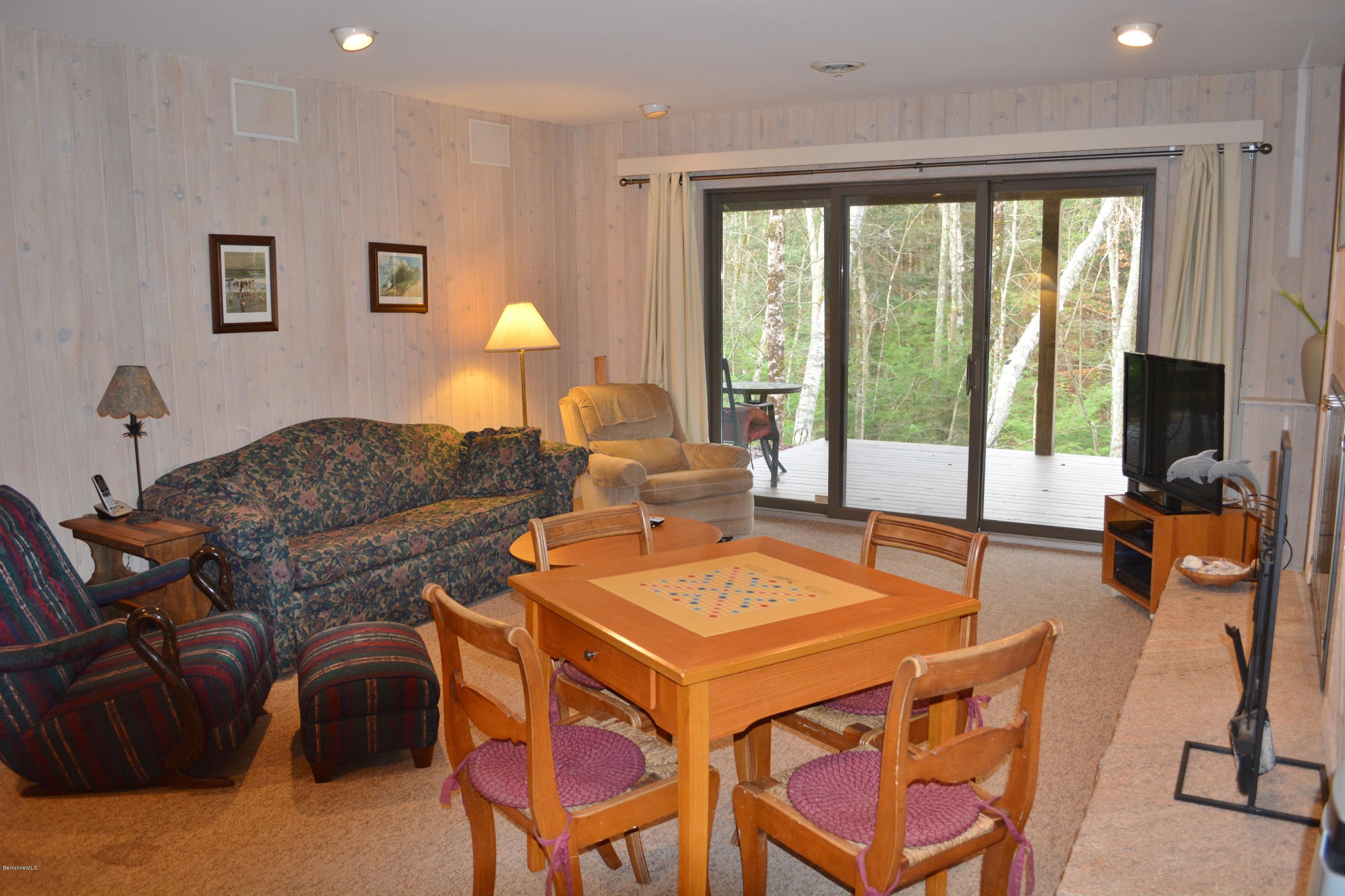 138 Bonny Rigg Hill Road Becket, MA 01223 - Photo 25 of 39 a living room with furniture a flat screen tv and a floor to ceiling window