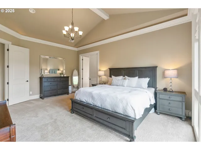 a spacious bedroom with a bed and a chandelier