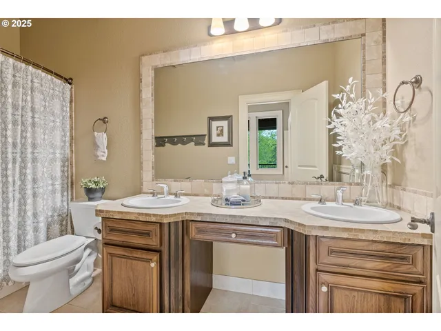 a bathroom with a granite countertop sink mirror and toilet