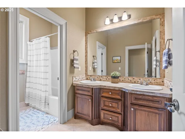 a bedroom with a bed a dresser and next to a window