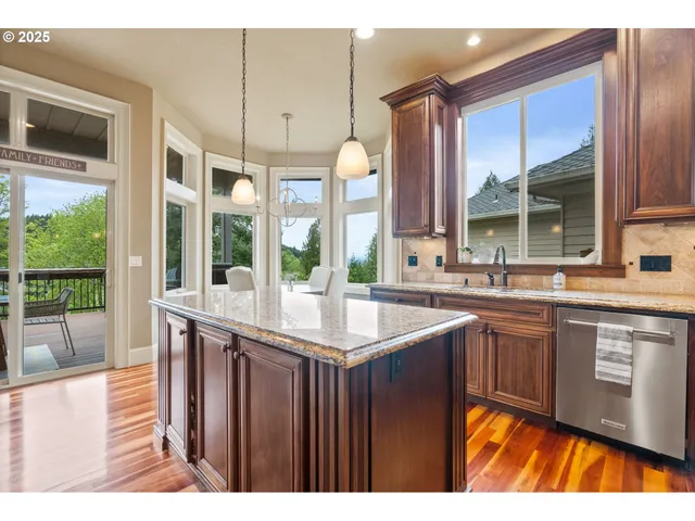 a kitchen with kitchen island granite countertop a sink and a stove