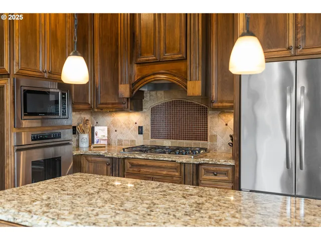 a kitchen with kitchen island granite countertop a stove a sink and a microwave