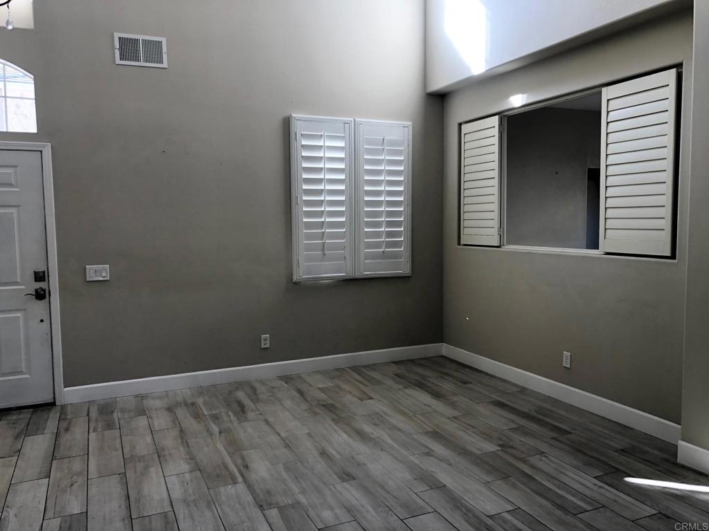 130 Venetia Way Oceanside, CA 92057 - Photo 3 of 19 a view of an empty room with wooden floor and a window