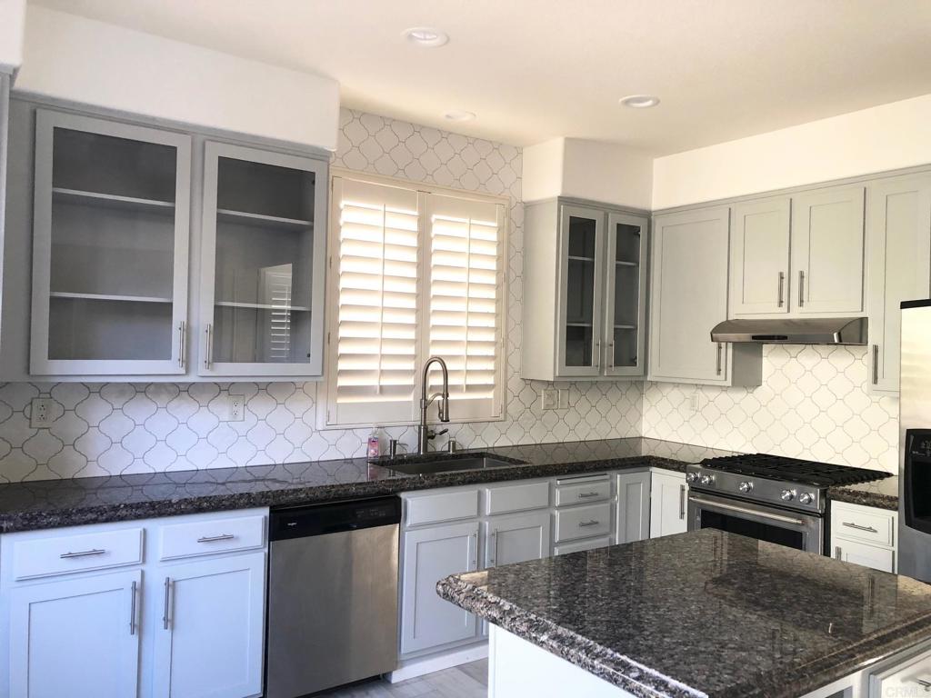 130 Venetia Way Oceanside, CA 92057 - Photo 6 of 19 a kitchen with granite countertop a sink a stove and cabinets