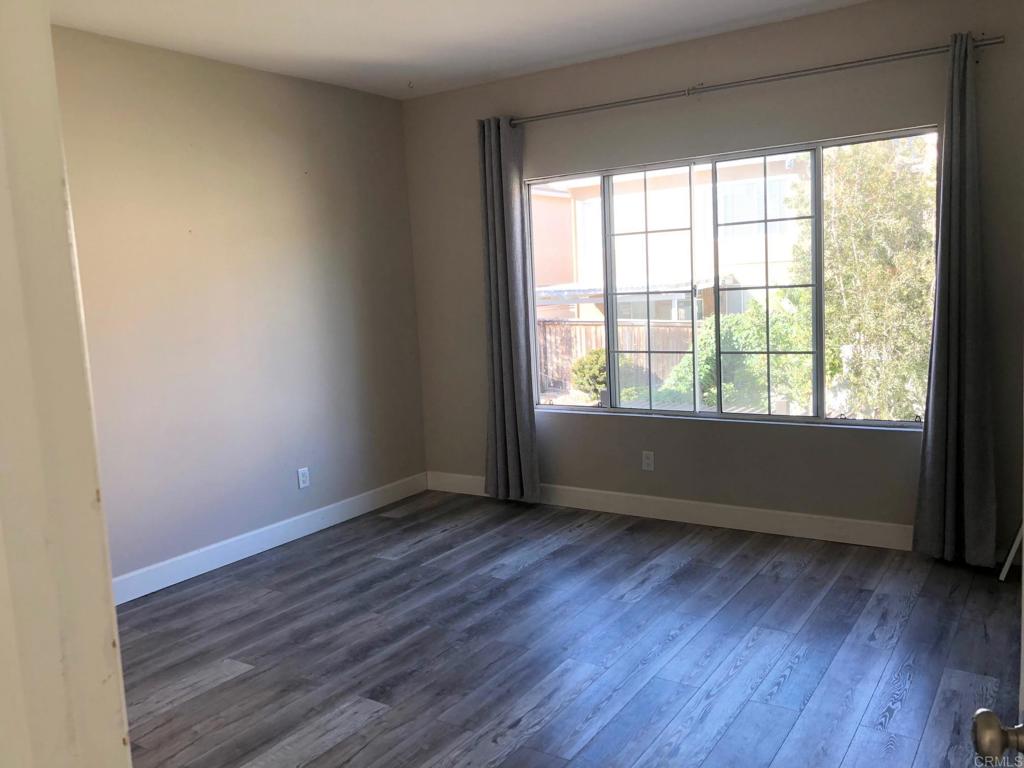 130 Venetia Way Oceanside, CA 92057 - Photo 8 of 19 an empty room with wooden floor and windows