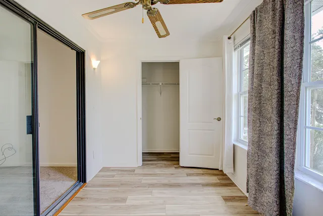 a view of a hallway with wooden floor and cabinet