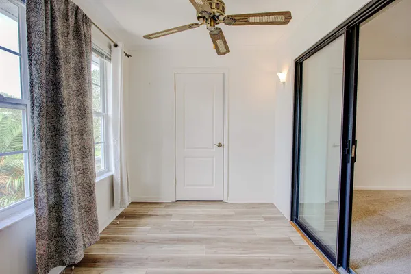 a view of a hallway with wooden floor and front door