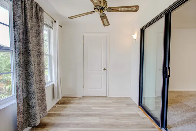 a view of a hallway with wooden floor and front door