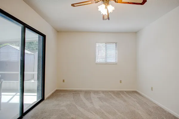 an empty room with chandelier fan