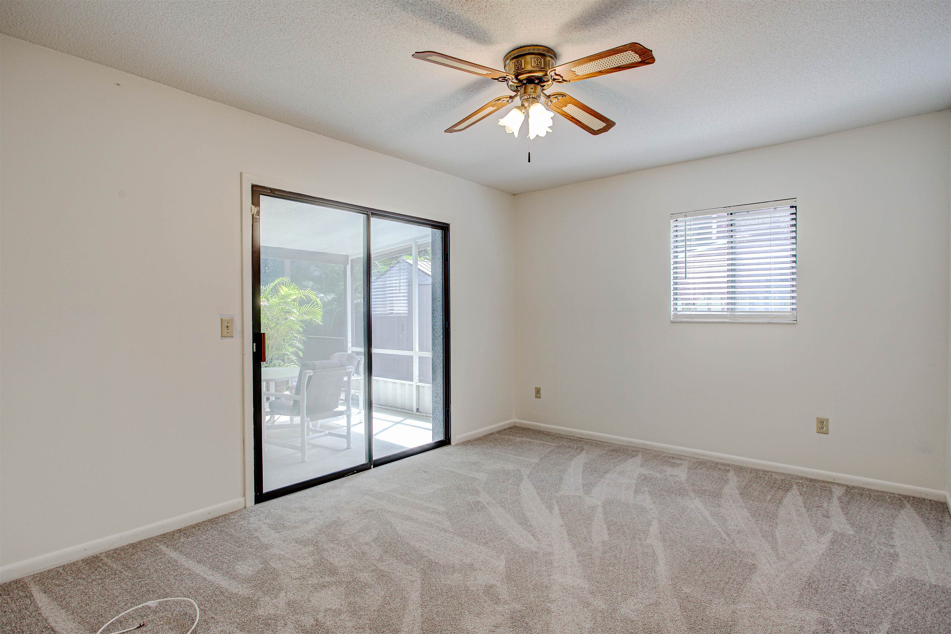 21 Atlantic Oaks Circle St. Augustine, FL 32080 - Photo 18 of 21 an empty room with chandelier fan and windows