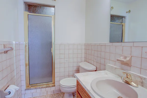 a bathroom with a sink a toilet and shower