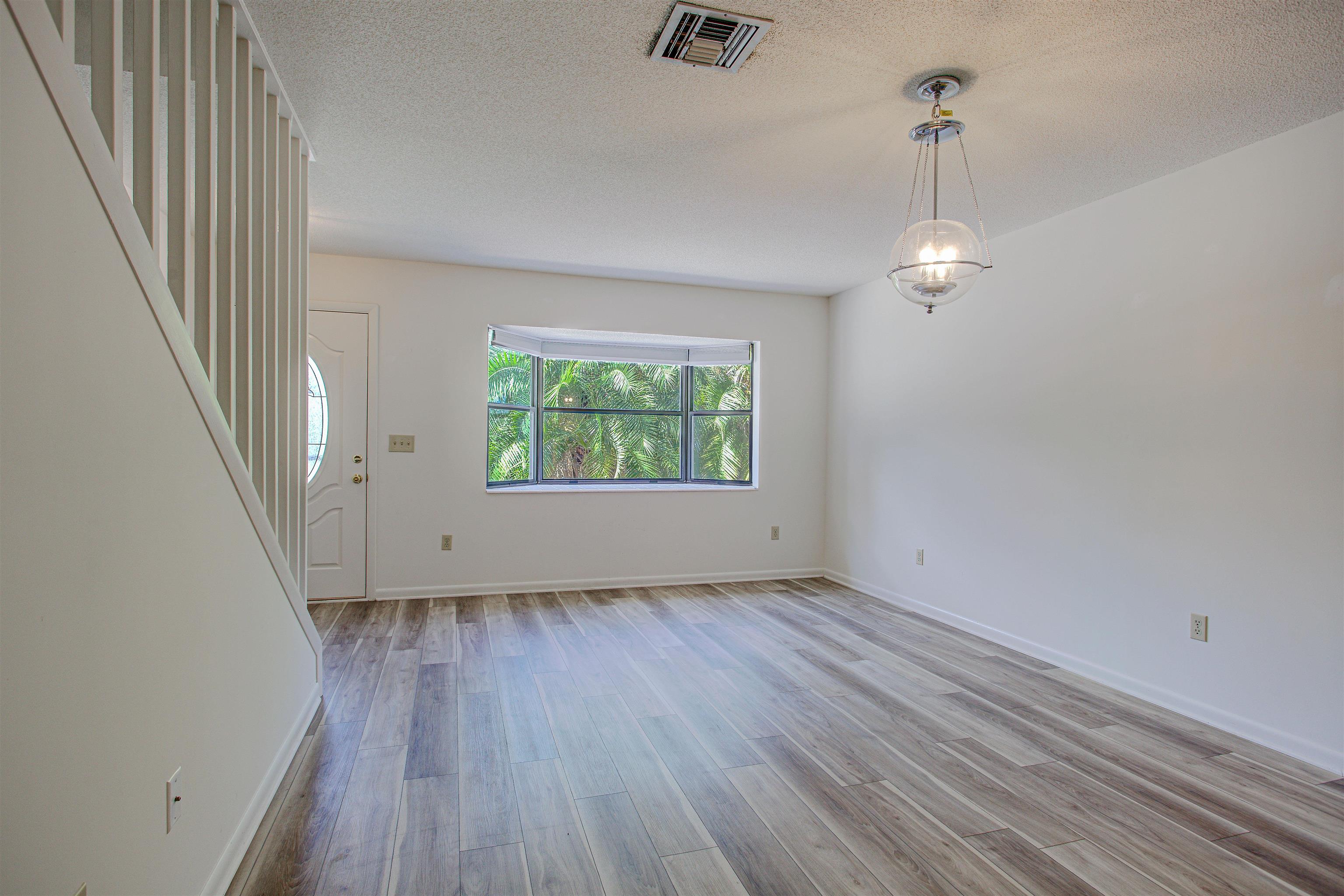 21 Atlantic Oaks Circle St. Augustine, FL 32080 - Photo 9 of 21 an empty room with wooden floor mirror and windows