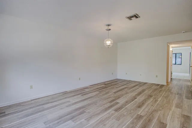 a view of empty room with wooden floor