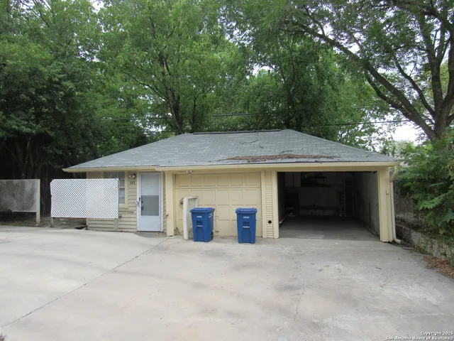 a view of a house with a yard and large tree