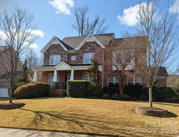 a front view of a house with a yard covered with snow