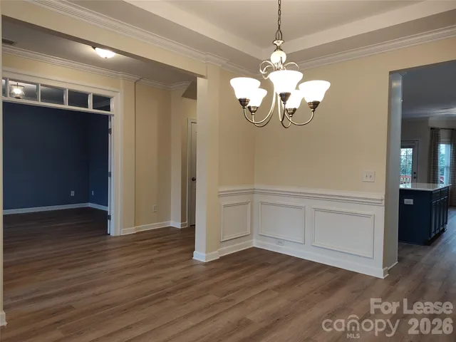 a view of an empty room with wooden floor and window