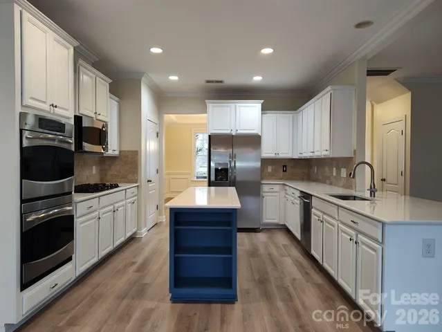 a large kitchen with stainless steel appliances lots of counter space sink and cabinets