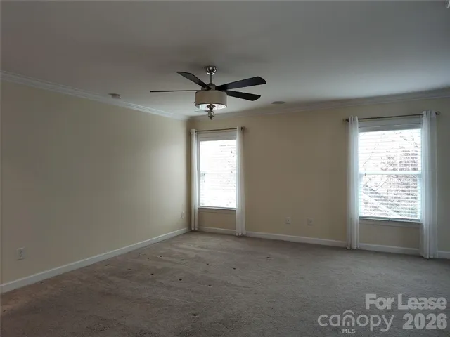 an empty room with a window and a ceiling fan