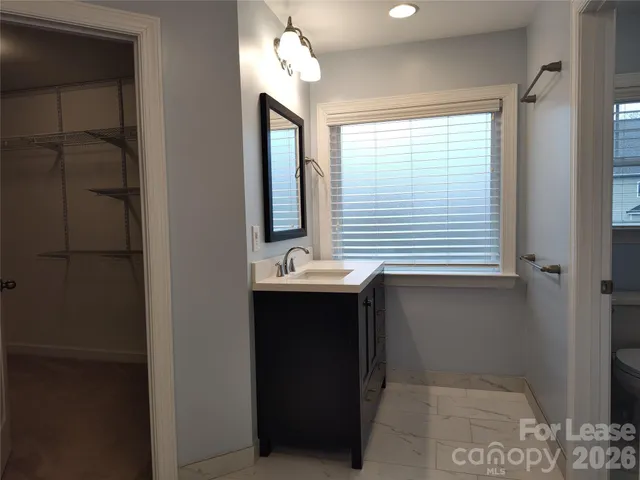 a bathroom with a sink a mirror and a window