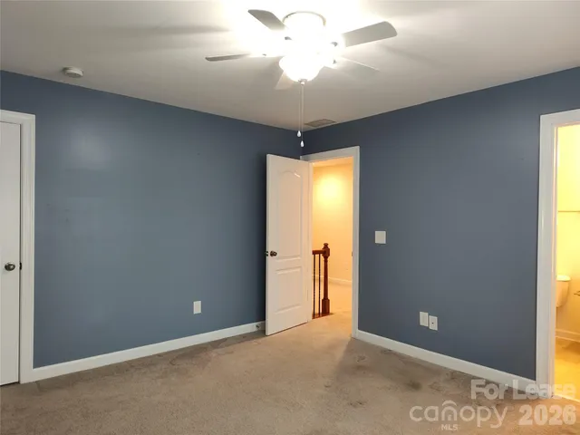 an empty room with closet and a chandelier fan