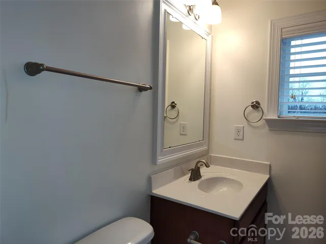 a bathroom with a sink toilet and mirror