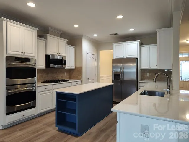 a kitchen with kitchen island a sink appliances and cabinets