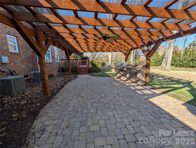 a view of a backyard with table and chairs under an umbrella with a small yard