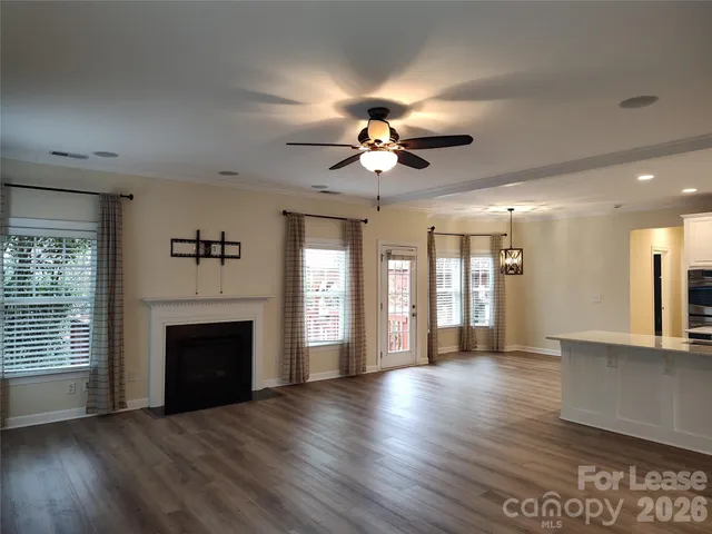 an empty room with wooden floor fireplace and a window