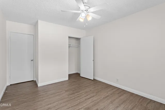a view of an empty room with wooden floor