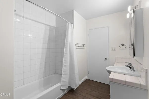 a bathroom with a granite countertop sink a mirror and a bathtub