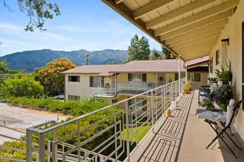 a view of a house with wooden deck and furniture