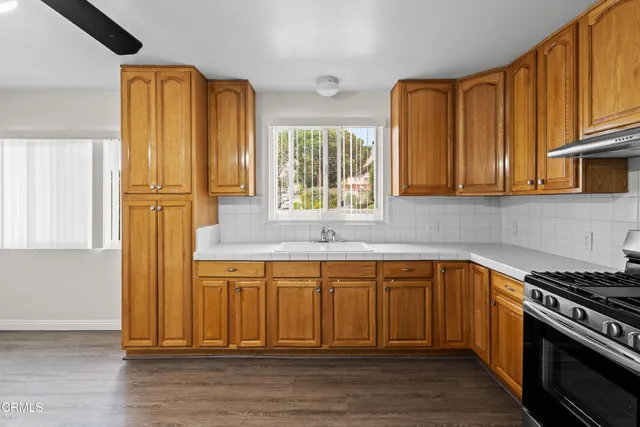 a kitchen with stainless steel appliances wooden floor and a window