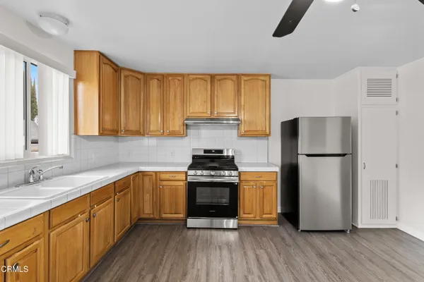 a kitchen with granite countertop a stove a refrigerator and a sink