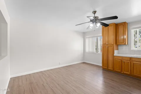 a view of a livingroom with wooden floor and a ceiling fan