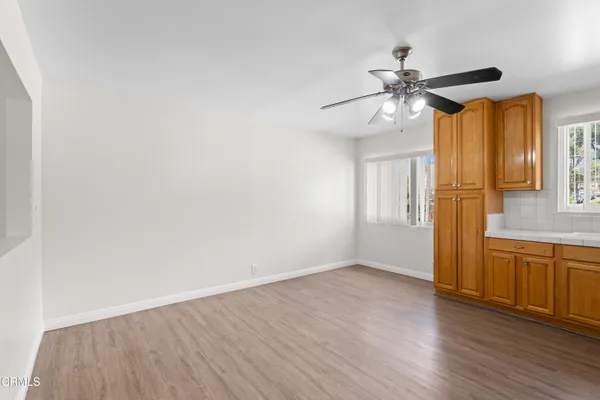 a view of a livingroom with wooden floor and a ceiling fan